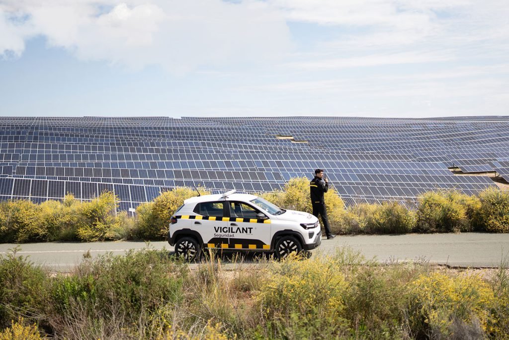 Un vigilante de seguridad privada controla desde un coche de Grupo Vigilant una plantación solar.